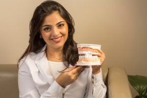 Dentist holding a prosthetic set of teeth
